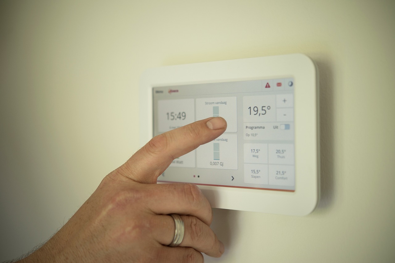 A finger is tabbing the temperature control device for the bedroom
